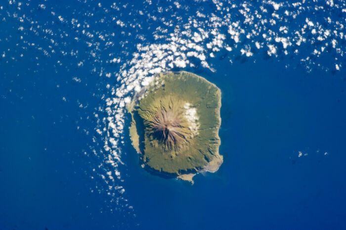 Aerial view of a remote island surrounded by blue ocean, highlighting random knowledge of geography.