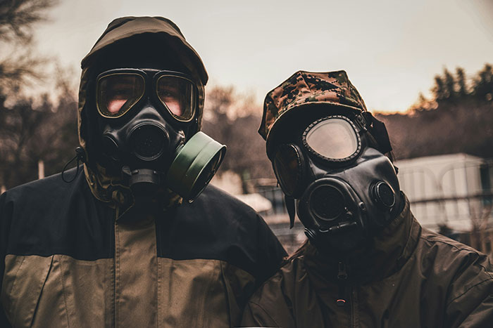 Two people wearing gas masks and hooded jackets, highlighting weird and fascinating science facts.