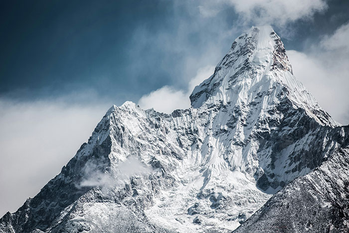 Snow-covered mountain peak under a cloudy sky, illustrating fascinating science.