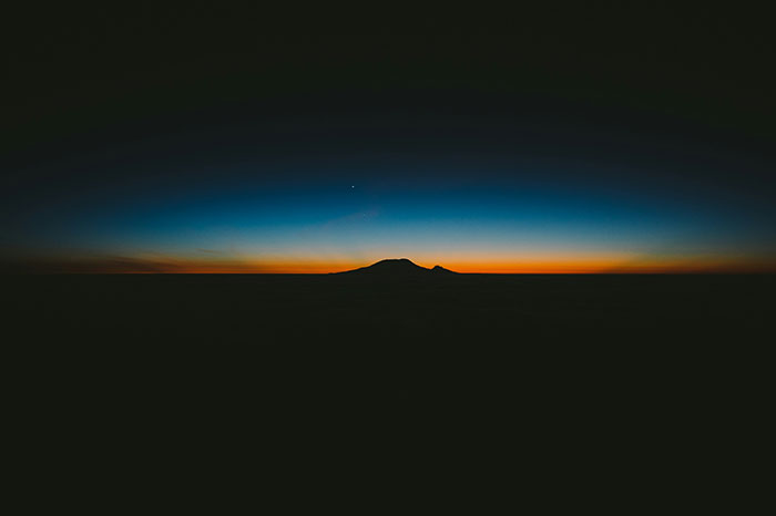 Silhouette of a mountain under a colorful dusk sky, illustrating fascinating science views.