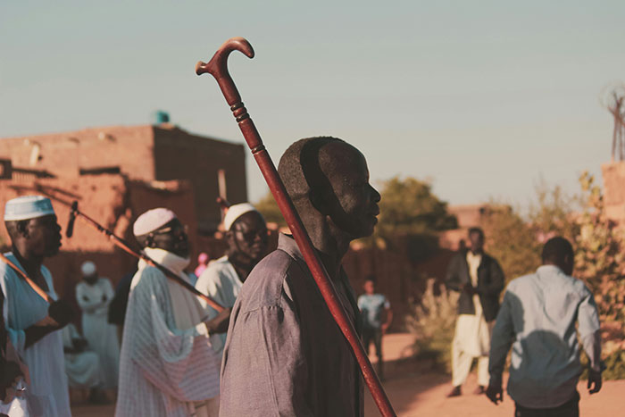 People gathered outdoors in warm light, carrying walking sticks, illustrating fascinating science facts in a rustic setting.