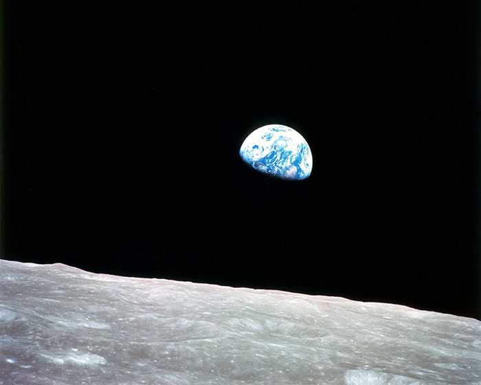 Earth rising over the moon's horizon, illustrating fascinating science facts about our universe.