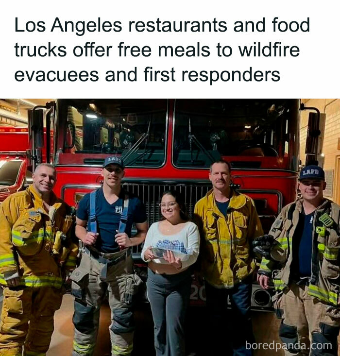 Firefighters with a community member in front of a fire truck, receiving free meals from local restaurants in Los Angeles.