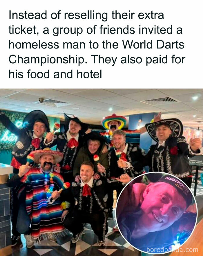 Group of friends in sombreros with a homeless man at World Darts Championship, spreading positive vibes.