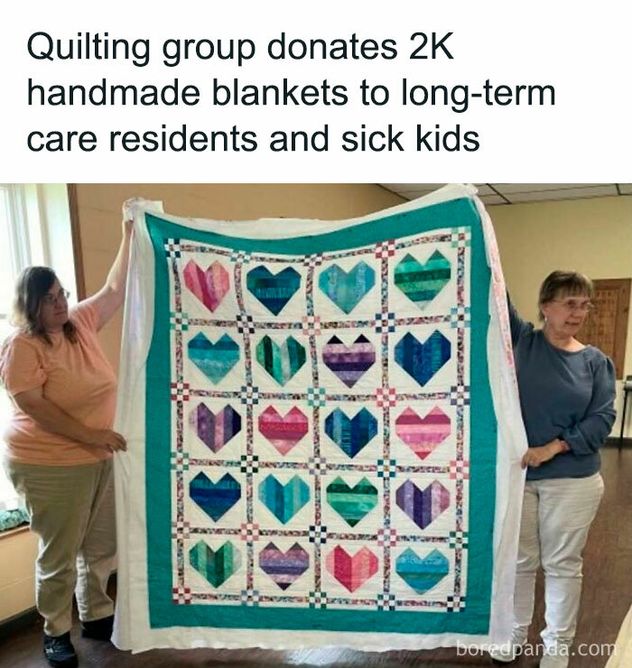 Quilting group holds a colorful heart-patterned blanket, donated to residents and sick kids for positivity.