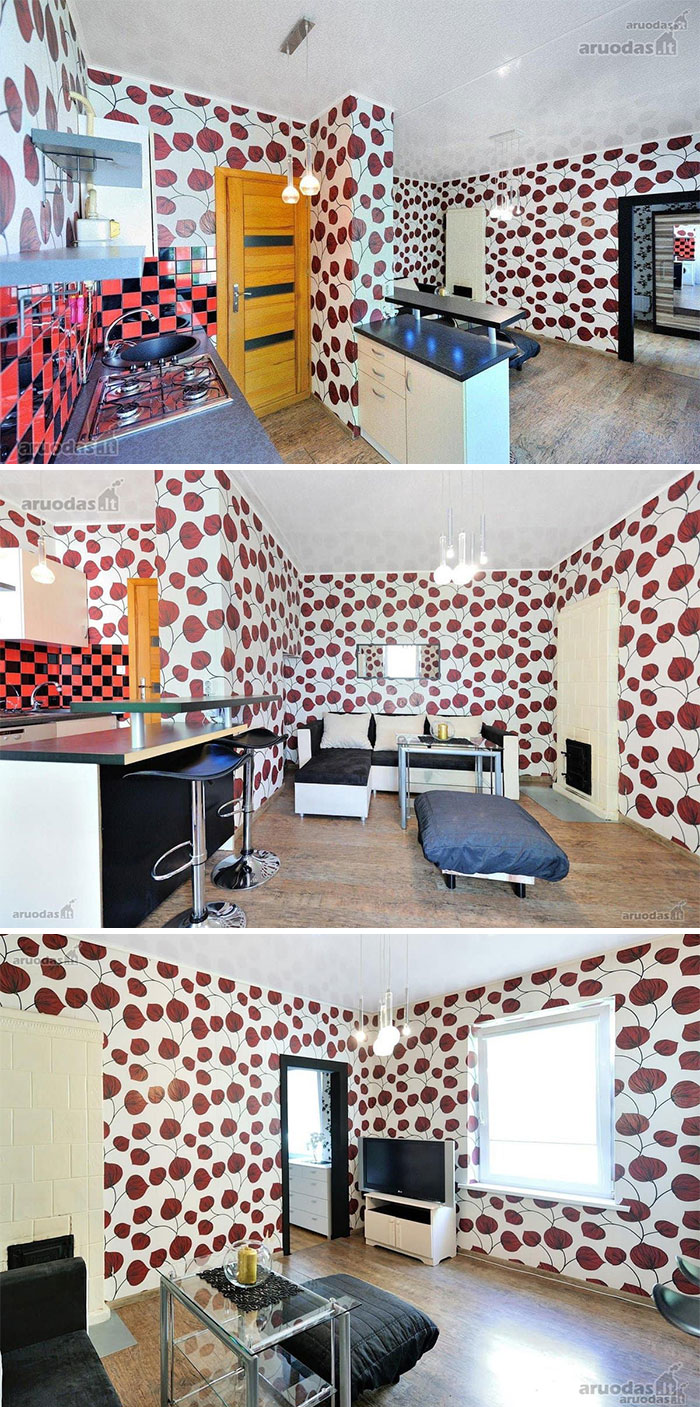Interior of a wild real estate property featuring bold red leaf wallpaper, modern kitchen, and contemporary living room furnishings.