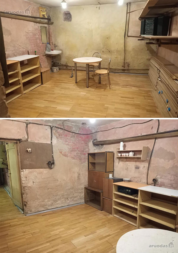 Basement room with worn walls, exposed pipes, mismatched furniture, and hardwood floors in a wild real estate property.