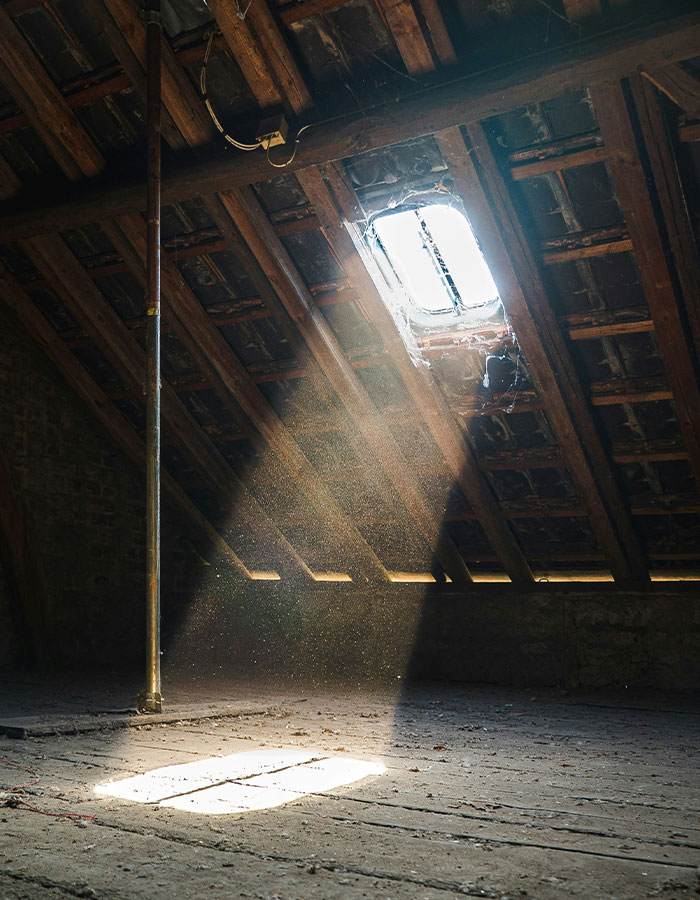Sunlight streaming through an attic window, highlighting dust particles in the air. Sunlight streaming through an attic window, highlighting dust particles in the air.