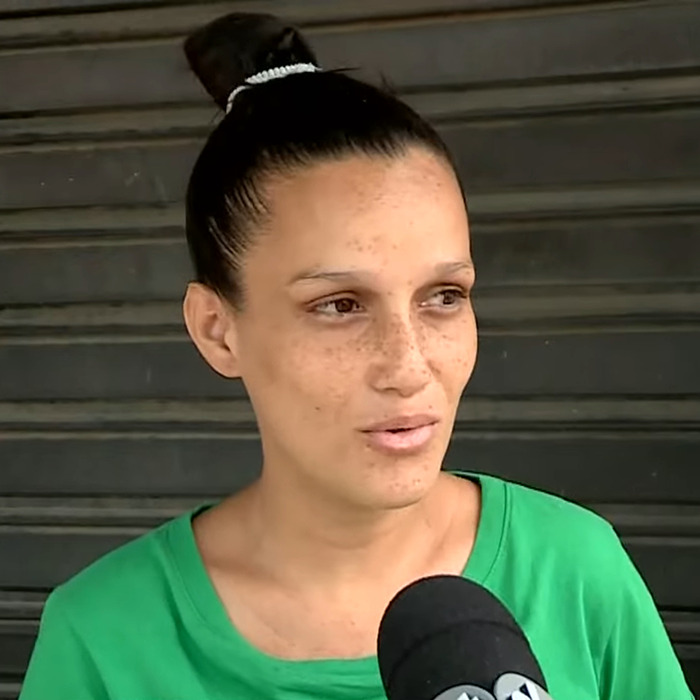Pregnant woman in a green shirt speaking, related to one baby delivery instead of twins.