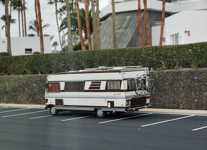 A parked caravan in a driveway, highlighting a property setting, with a bicycle mounted on the back.