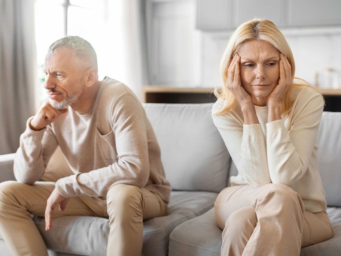Couple on sofa, woman worried, reflecting on secret name change.