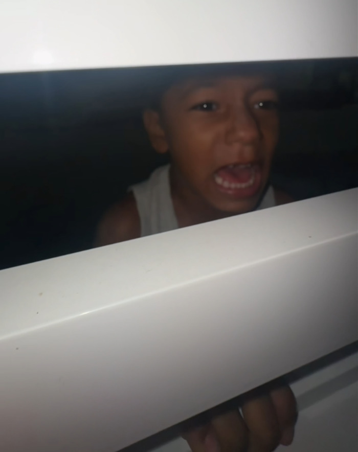 Young boy locked outside, reaching and shouting through a window in a lesson about gender roles and staying home. Young boy locked outside, reaching and shouting through a window in a lesson about gender roles and staying home.