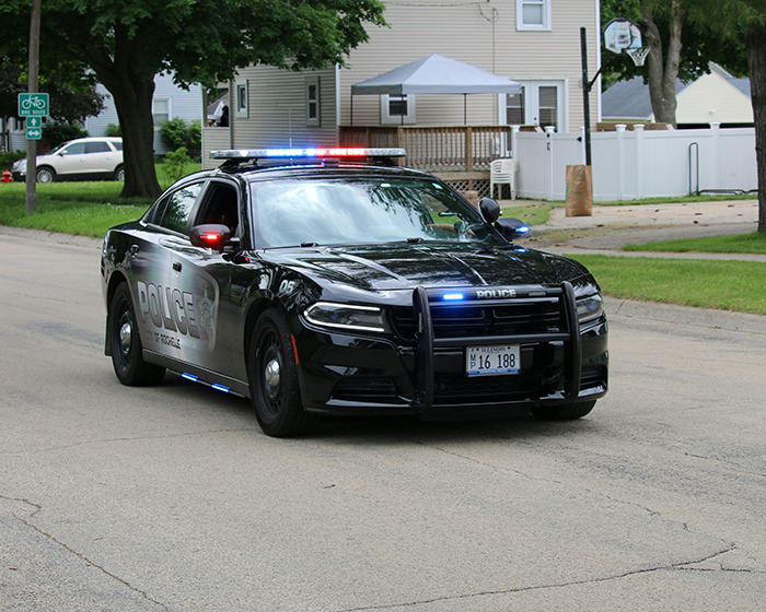 Police car with lights on parked in suburban street during a response, related to women finding toddlers. Police car with lights on parked in suburban street during a response, related to women finding toddlers.