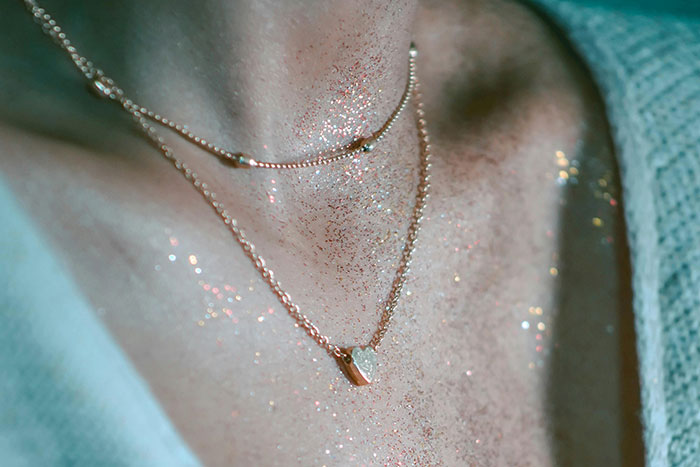 Woman wearing glitter on her neck and chest as deterrent, with a gold necklace. Woman wearing glitter on her neck and chest as deterrent, with a gold necklace.