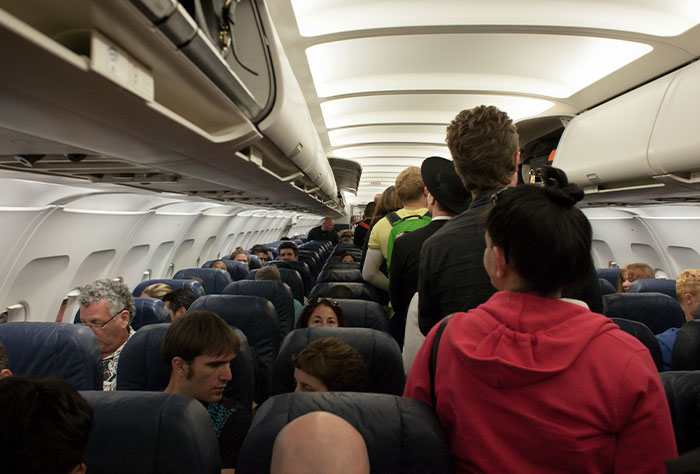 Passengers boarding a plane, illustrating potential for worst plane seatmates experience.