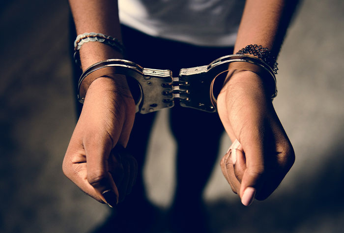 Hands in handcuffs, representing worst plane seatmates scenario.