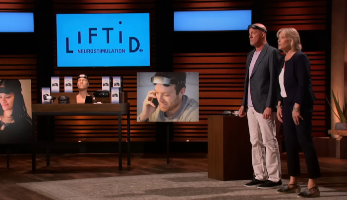 Two presenters pitching a neurostimulation device on Shark Tank, one wearing the product on their head.