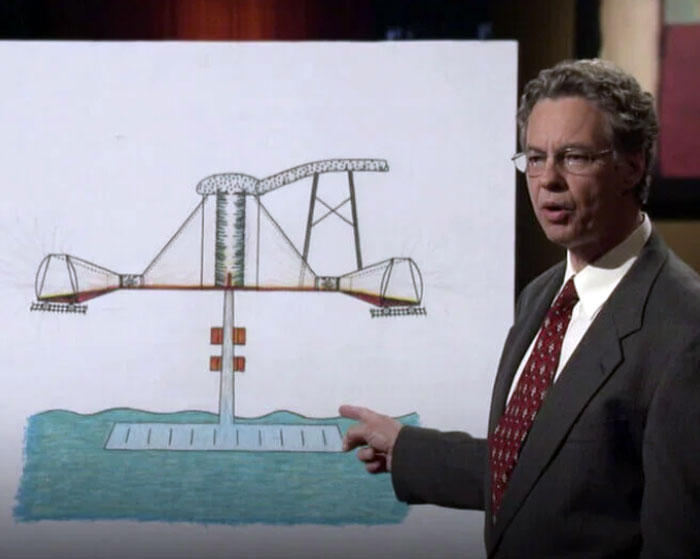 Man in suit presenting a product design on a large board, one of the shark tank products that completely flopped