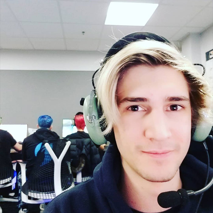 Streamer xQc with headset in gaming setup, highlighting net worth insights.