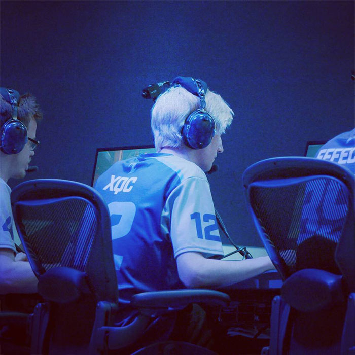 Esports player wearing a jersey with "xQc" on the back, focused on gaming.