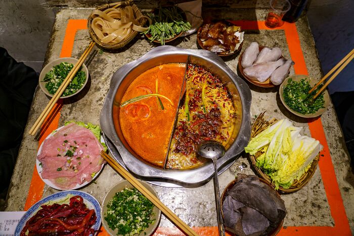 Traditional hot pot with various meats and vegetables, showcasing a popular dish from different countries.