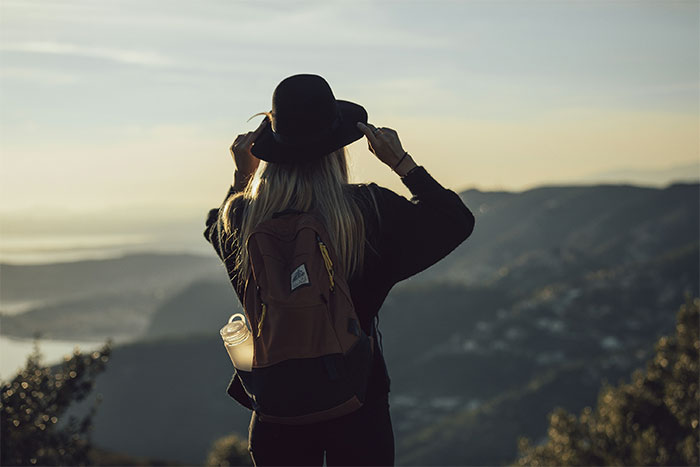 Woman with backpack and hat enjoying a solo holiday, contemplating what to do when a friend invites herself along. Woman with backpack and hat enjoying a solo holiday, contemplating what to do when a friend invites herself along.