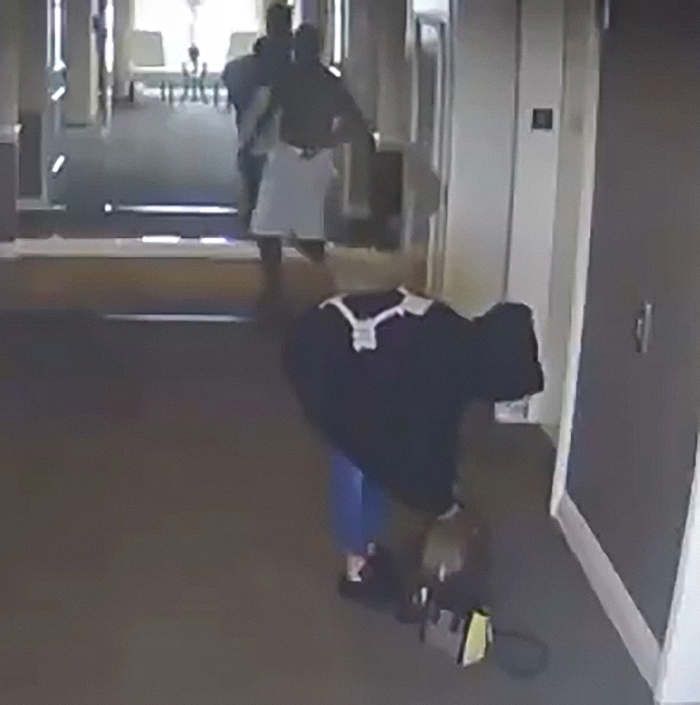Person bending down in a hallway with others walking ahead, related to Diddy trial jury and Freak Off parties evidence. Person bending down in a hallway with others walking ahead, related to Diddy trial jury and Freak Off parties evidence.