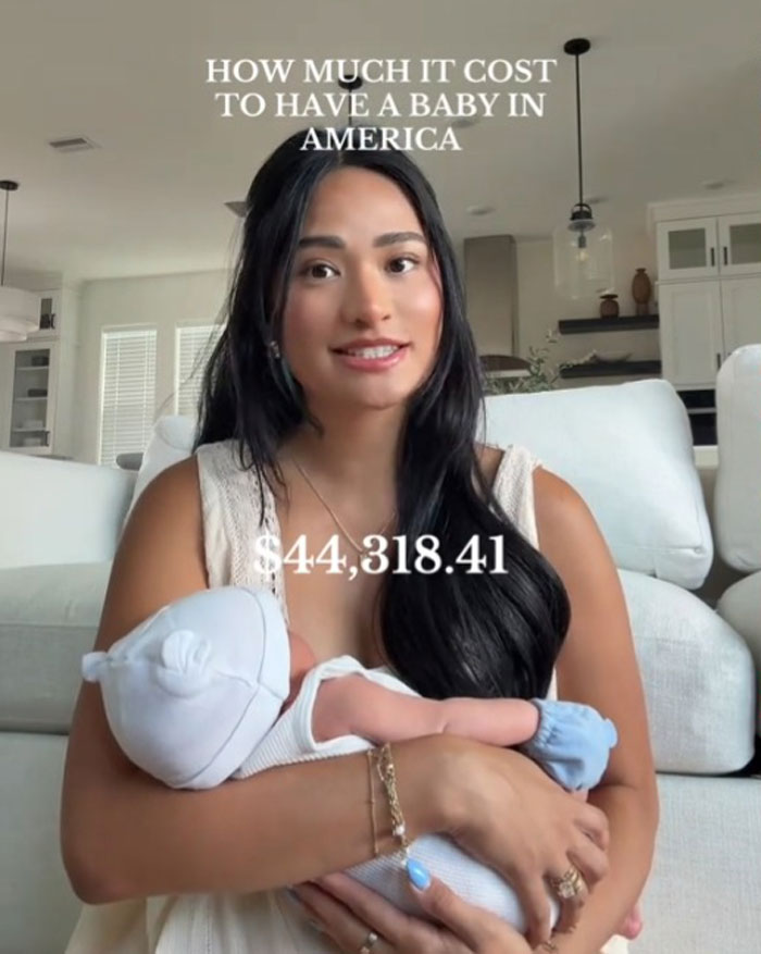New mom holding baby boy at home, explaining the expensive cost to give birth in the US, $44,318.41 displayed.