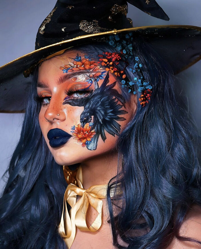 Woman with artistic makeup featuring a black bird and flowers, wearing a witch hat, showcasing incredible makeup looks by talented artists.