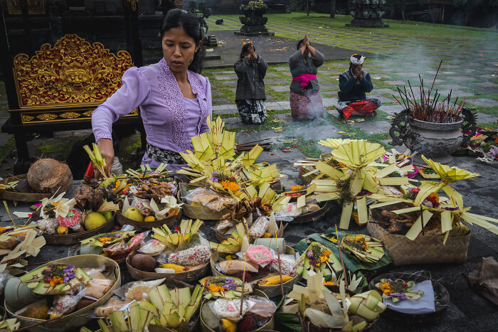 Local people preparing traditional offerings during a vibrant street photography moment capturing cultural rituals.