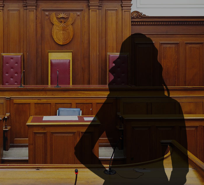 Courtroom interior with empty witness stand and silhouette representing alleged victim in Diddy case testimony.