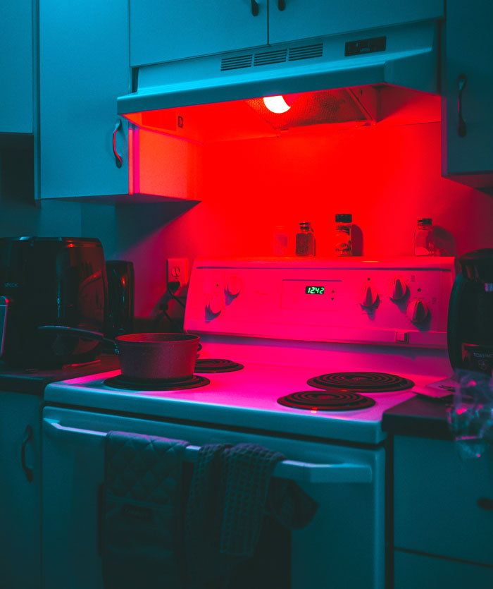 Kitchen stove illuminated by red light, with a pot on the burner, reflecting on one weird rule parents had.