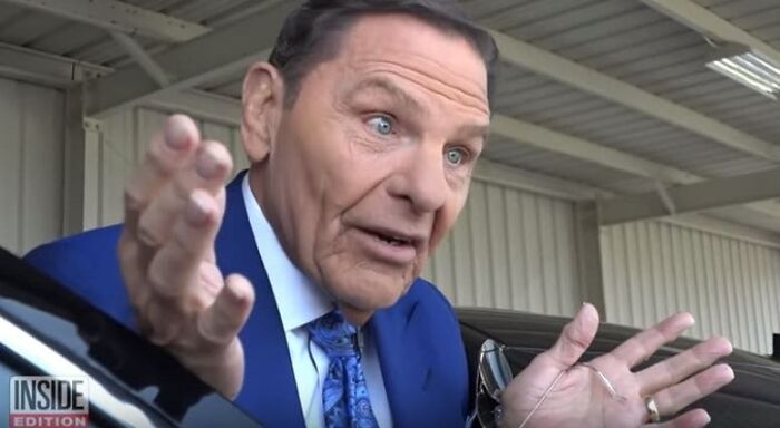 Man in blue suit gesturing with hands, discussing controversial earnings in jobs that shouldn’t be this high.