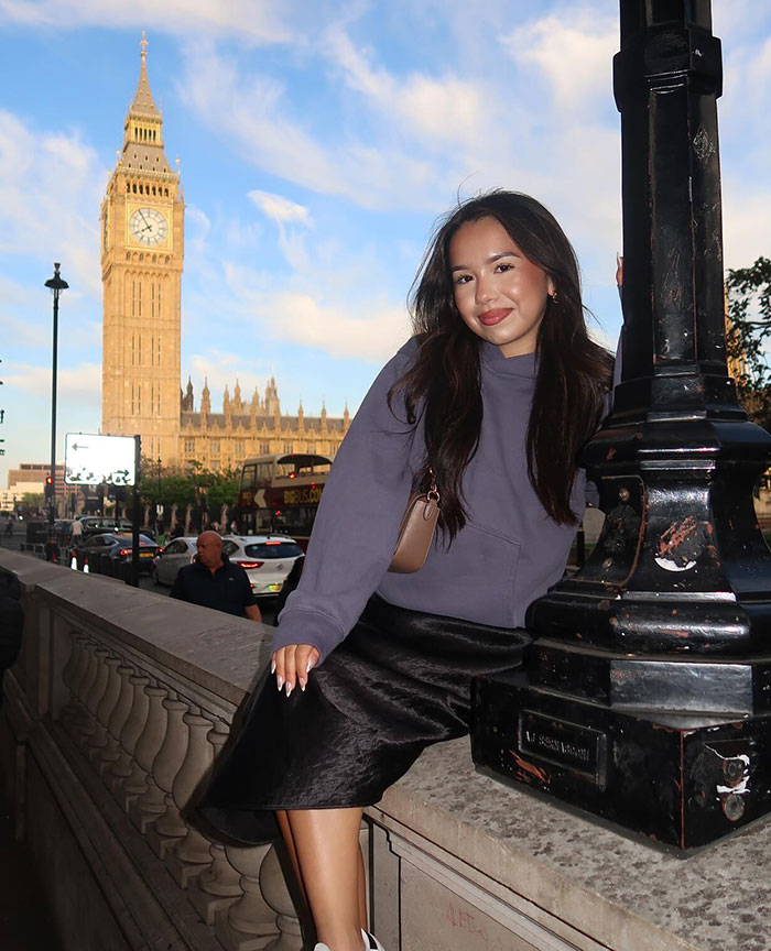Young woman posing near a lamppost with Big Ben in the background, unrelated to TSA bag mix-up incident.