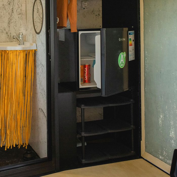 Small open refrigerator inside a room with alcohol cans visible, suggesting a teen sneaking alcohol from a roommate’s space. Small open refrigerator inside a room with alcohol cans visible, suggesting a teen sneaking alcohol from a roommate’s space.