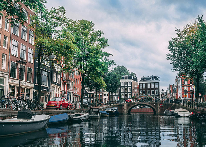 Canal in a European city with boats and historic buildings, illustrating people's views on living in their home countries.