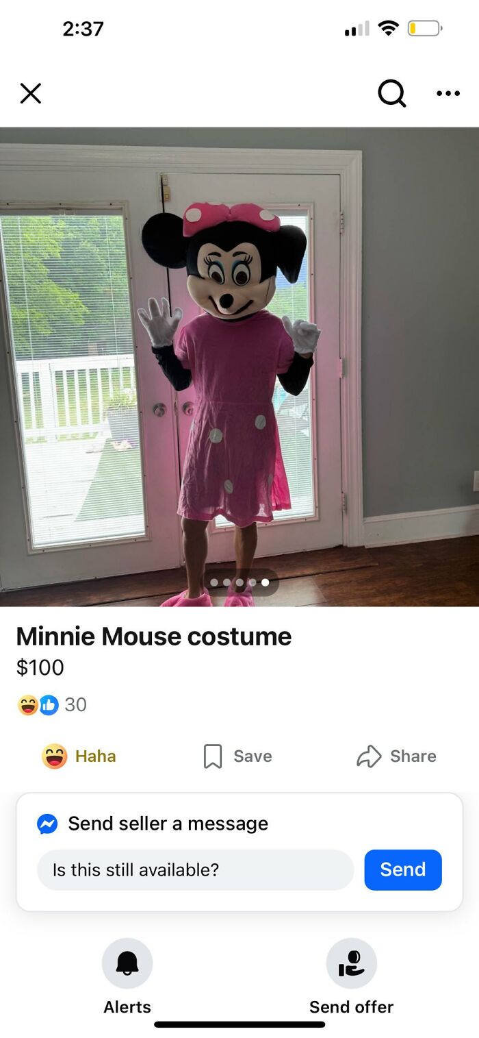 Person wearing a pink Minnie Mouse costume listed for sale on Facebook Marketplace in a well-lit room near glass doors
