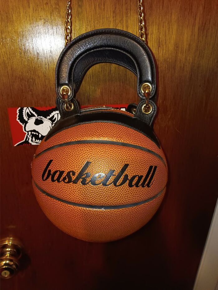 Unique thrifted basketball handbag with black leather handle, showcasing a weird and wonderful vintage find.