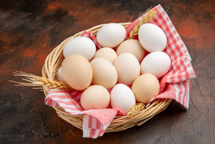 Basket of brown and white eggs on a red checkered cloth highlighting products requiring extra caution while cooking and eating.