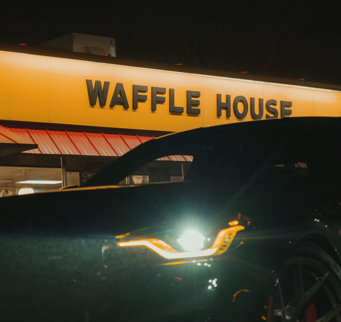 Waffle House at night with a car in front, illustrating one weird rule your parents had you thought was normal.