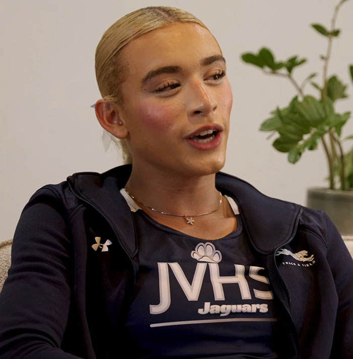 Young high school athlete wearing JVHS Jaguars track uniform speaking in an indoor interview setting.