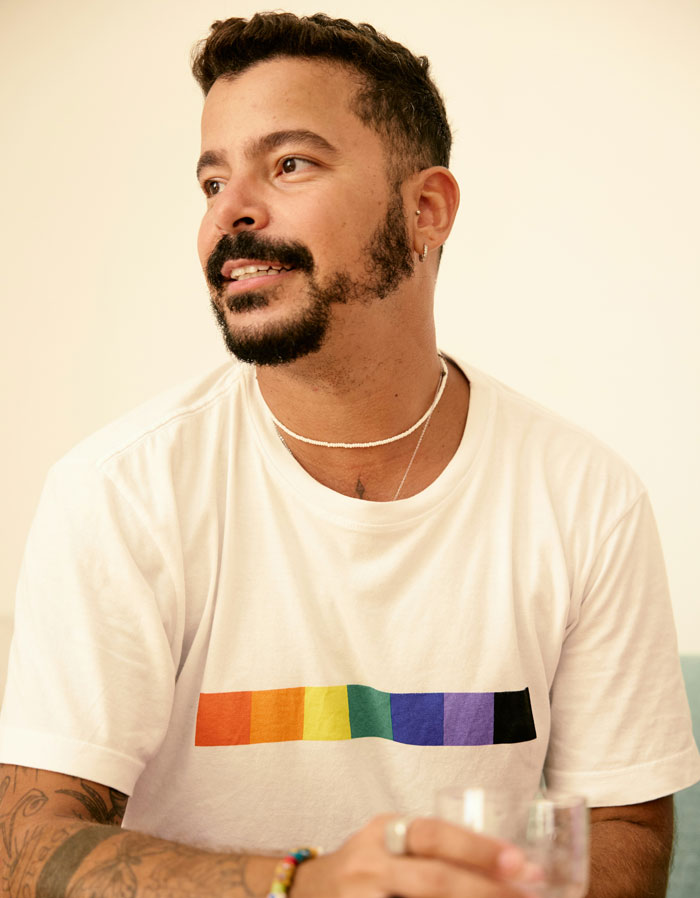 Man with beard wearing a rainbow-striped shirt, representing views on problematic behaviors women get a pass for according to men.