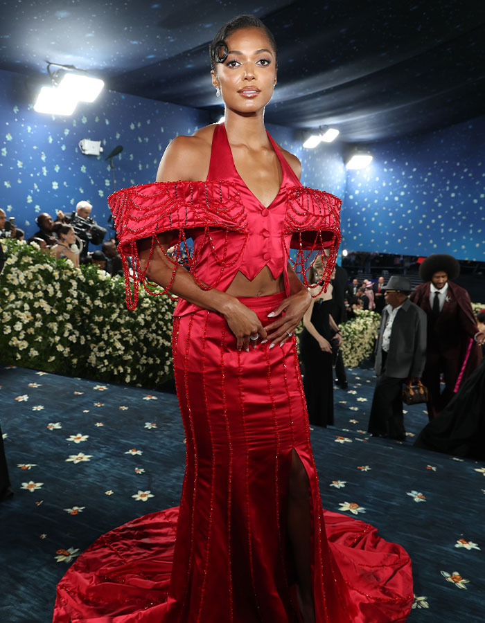 Woman wearing an elaborate red gown with beaded details at an event known for biggest fashion fails Met Gala 2025.
