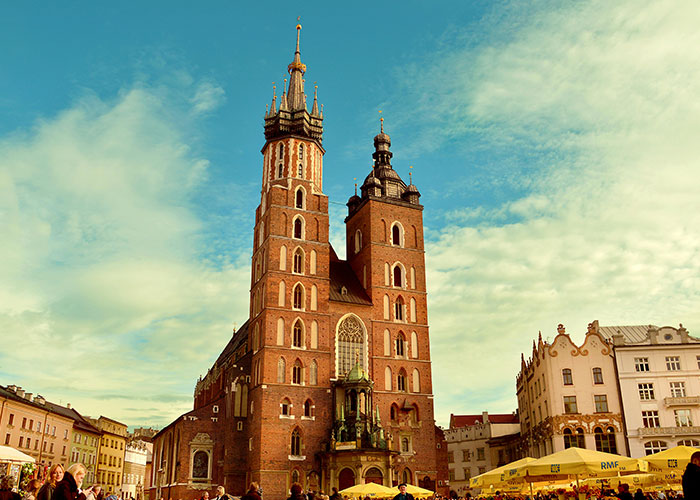 Historic European city square with a large brick cathedral, illustrating living in home countries and cultural experiences.