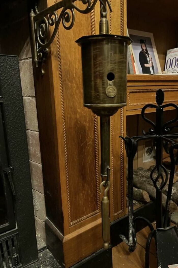 Antique brass mechanical device found near a fireplace, a strange thing in homes with hidden or haunted pasts.
