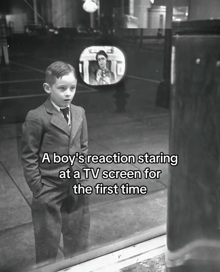 A boy experiencing monumental life moment, reacting with awe while watching a TV screen for the first time.