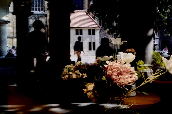 Street photography scene with silhouettes and flowers, reflecting the spirit of Pure Street Photography Grant winners.