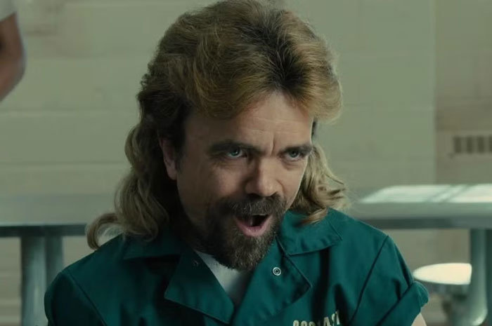 Man with mullet hairstyle and beard wearing a green jacket, recalling times strangers unsuccessfully attempted to mug him.