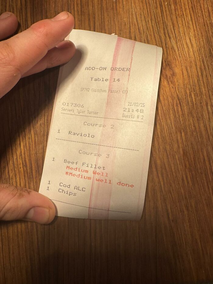 Hand holding a restaurant order slip with food items, illustrating a relatable hospitality work meme moment.