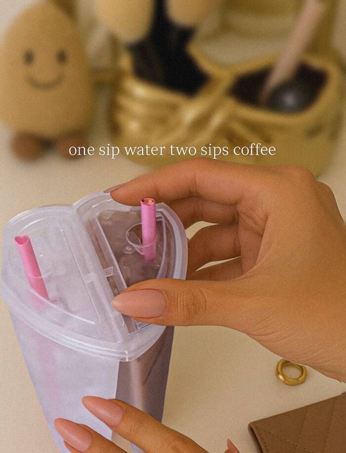 Hand holding heart-shaped cup with pink straws and cute decor, reflecting cute and wholesome posts shared by girlies.